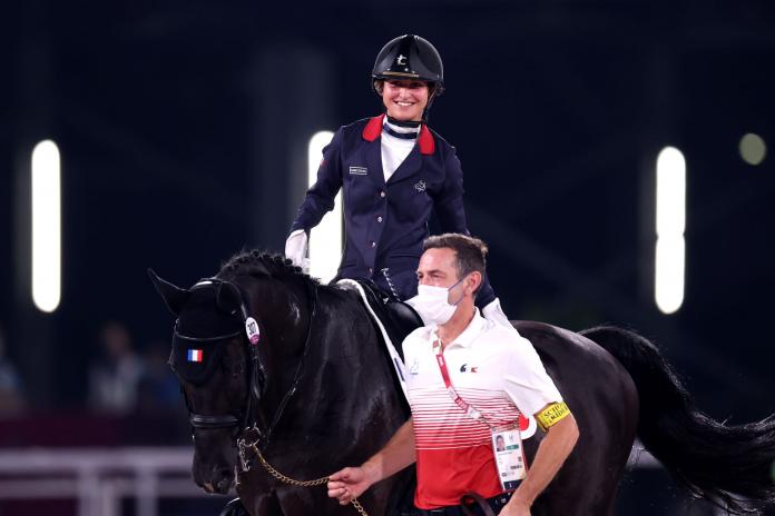 A female Para equestrian athlete rides a horse